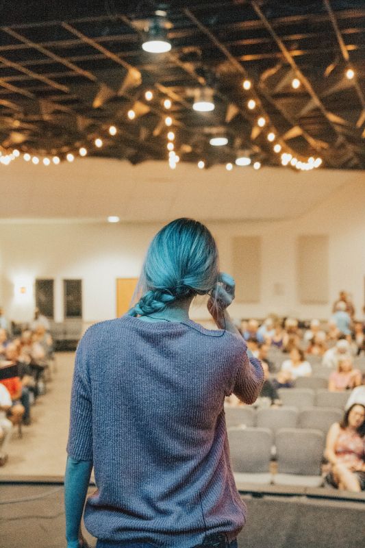 young woman standing on a stage in front of an audience
