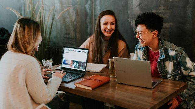 group of women discussing over laptops