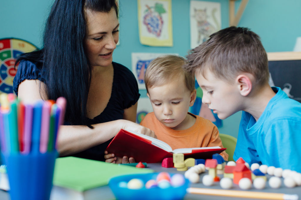 Mother reading a book to her children