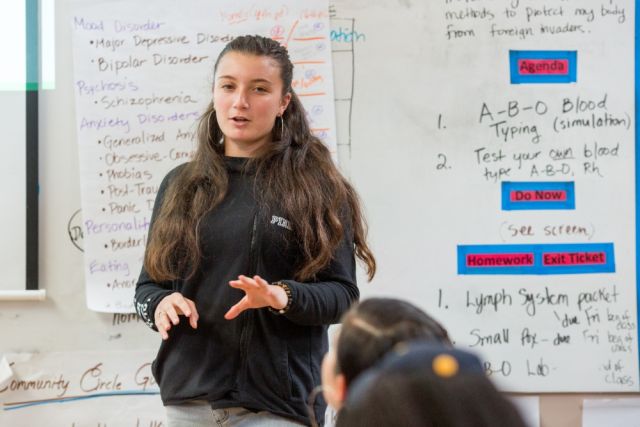 student talking at the front of the classroom