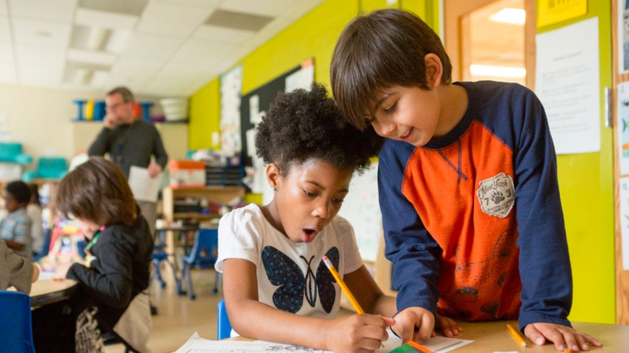 two students excitedly working on a worksheet