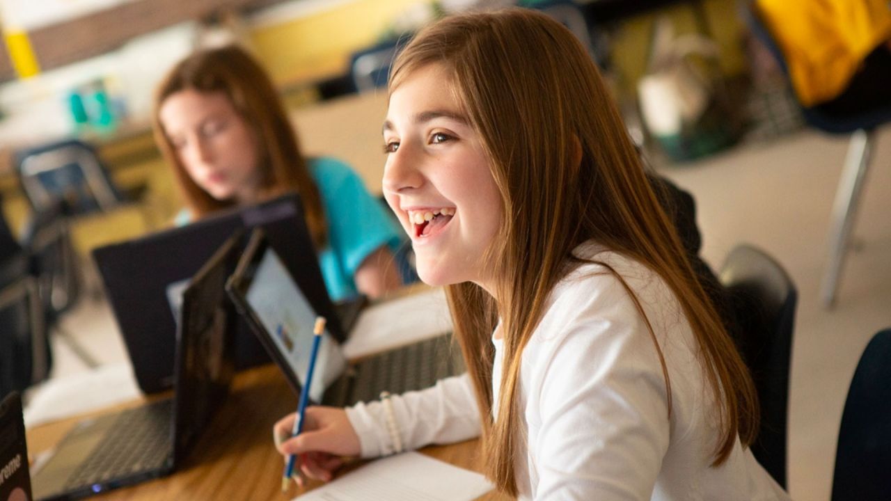 young student smiling while doing work