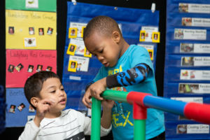 Students building with colorful pipes.