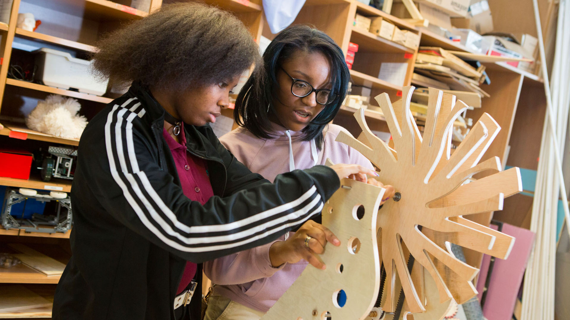 Tenth-grade girls work on engineering project Students working on an engineering project made of wood.