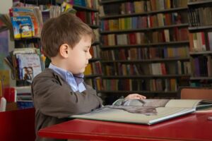 Student reading a book in a library.