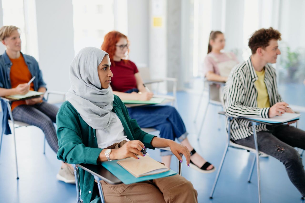 People sitting at desks in a classroom setting.