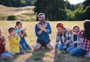 People in a circle, sitting down, outside.