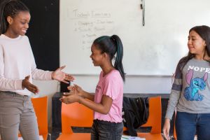 Middle school drama students participate in a warm-up exercise designed to promote teamwork.