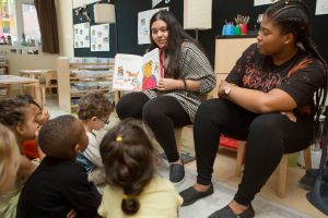 Student Teachers reading a book to preschoolers.